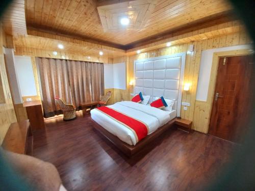 1 dormitorio con 1 cama grande con almohadas rojas y azules en Humble Holiday Inn Kufri Simla en Shimla