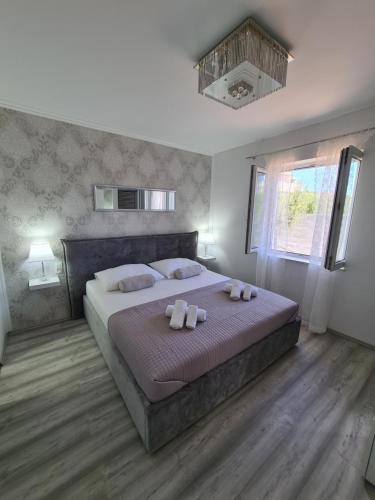 a bedroom with a large bed with two pillows at Villa M&M in Sevid