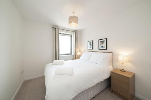 a bedroom with a large white bed and a window at At The Links in Carnoustie