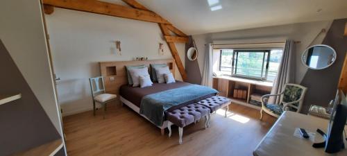 - une chambre avec un lit et une chaise dans l'établissement Bel Aujourd'hui Spa Sauna, à Cordelle
