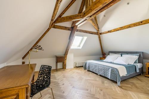 a bedroom with a bed and a desk in a attic at Casa La Palma Le 48 in Soissons