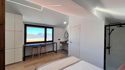 a bedroom with a bed and a window and a desk at Calma Suites Tejeda in Tejeda