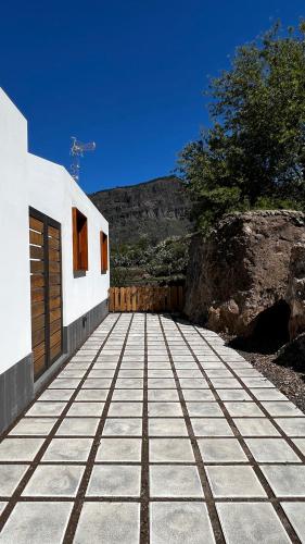a house with a stone floor and a wooden door at Calma Suites Tejeda in Tejeda