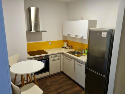 a small kitchen with a black refrigerator and a table at Cube Apartamenty in Lublin