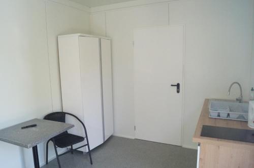 a small kitchen with a table and a white refrigerator at Mini Kemping Laguna in Mielno