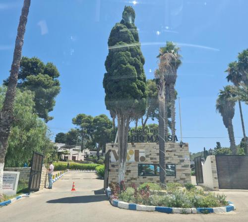 a monument at the entrance to a park with palm trees at Splendide duplex à MDIQ avec vue panoramique in M'diq