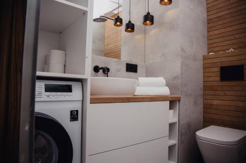 シュチェチンにあるJBHotels Apartament Prestigeの洗濯機と洗面台を備えたバスルーム