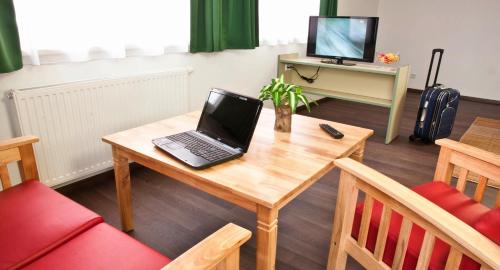 a laptop on a wooden table in a living room at WinRooms "hotel&apartments" in Wiener Neustadt