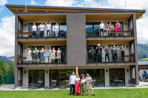 un grupo de personas de pie en los balcones de un edificio en Goldener Adler Oberried - Hotel & Appartements, en Oberried