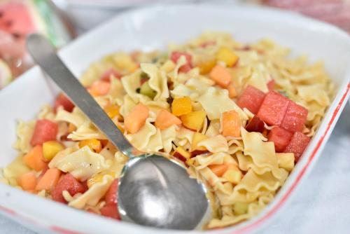 a bowl of pasta and vegetables with a spoon at Hotel Bel Sit in Comano Terme