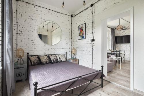 GrzmiącaにあるLoft Apartment Grzmiącaの白レンガの壁、ベッド付きのベッドルーム1室