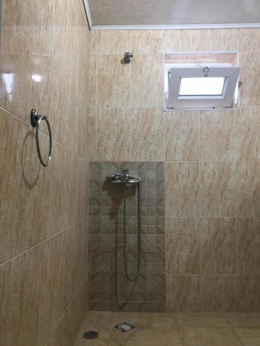 a bathroom with a shower with a window and a shower at Guest House Roman/Gonio in Gonio