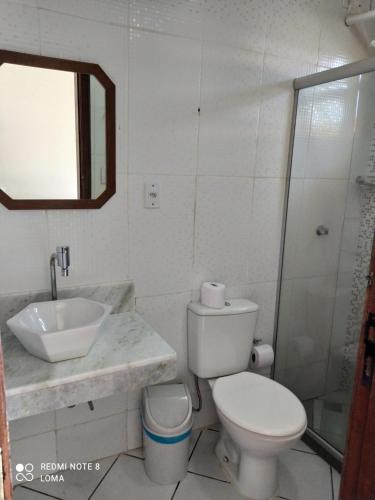 a bathroom with a toilet and a sink and a shower at Pousada Exuberante in Abraão