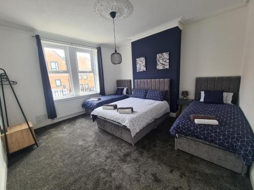 a bedroom with two beds and a window at 5 bed sleeps 6, 2 miles (7 mins) from city centre in Low Team