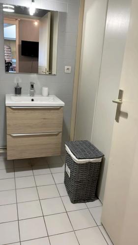 La salle de bains est pourvue d'un lavabo, d'un miroir et d'une poubelle. dans l'établissement Plénitude terrasse, au Mans