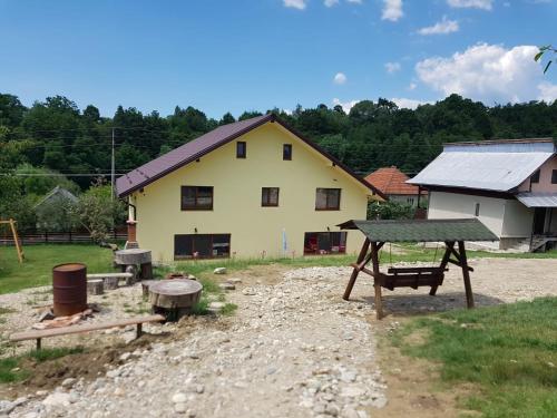 a house with a picnic table and a playground at Viata la Tara Cerna in Cerna