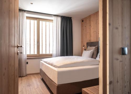 ein Schlafzimmer mit einem Bett und einem großen Fenster in der Unterkunft Oberfallerhof Apartment Ummi in Barbian