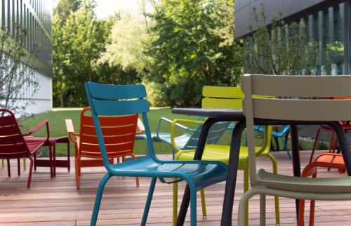 a group of colorful chairs and tables on a deck at sylc. Apartmenthotel – Serviced Apartments in Hamburg