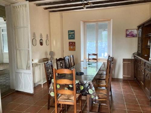 a dining room with a wooden table and chairs at Grande maison de charme, 14 pers. 5 chambres, sauna, écrin de verdure, baby foot in Saint-Clémentin