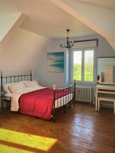 - une chambre avec un lit doté d'une couverture rouge et d'un piano dans l'établissement Grande maison de charme, 14 pers. 5 chambres, sauna, écrin de verdure, baby foot, à Saint-Clémentin