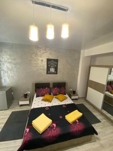 a bedroom with a large bed with yellow pillows at Garsoniera King Tip Studio in Năvodari