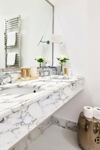 a white bathroom with a marble sink and mirror at Mondial Resort & Spa in Marina di Pietrasanta