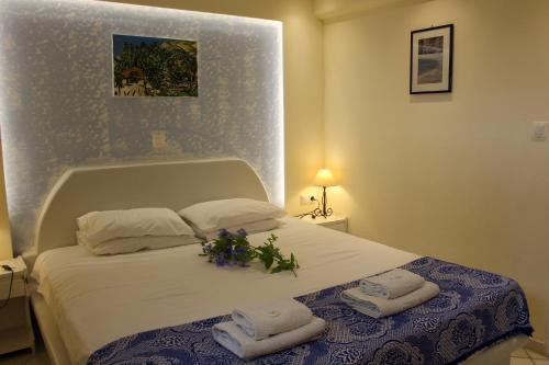 a bedroom with a bed with towels and flowers on it at Sea View Studios & Apartments in Agia Anna Naxos