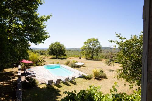 a swimming pool in the middle of a field at Cahors - Lot - Les Lumières du Causse - Domaine en pierres blanches avec vue sur les causses in Bellefont-La Rauze