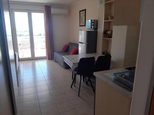 a kitchen and living room with a table and a refrigerator at Apartments Pehar in Zaostrog