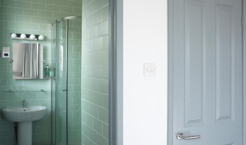 a bathroom with a glass shower and a sink at The Lerryn in Falmouth