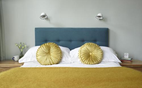 a bed with two large gold pillows on it at The Lerryn in Falmouth