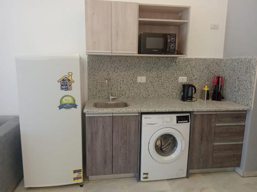 a kitchen with a washing machine and a refrigerator at Jasmine Resort & Aqua park in Sharm El Sheikh