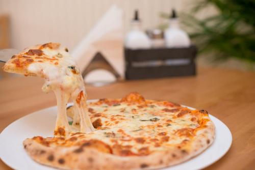 a slice of cheese pizza on a plate on a table at Seva Hotel Health Club in Campina