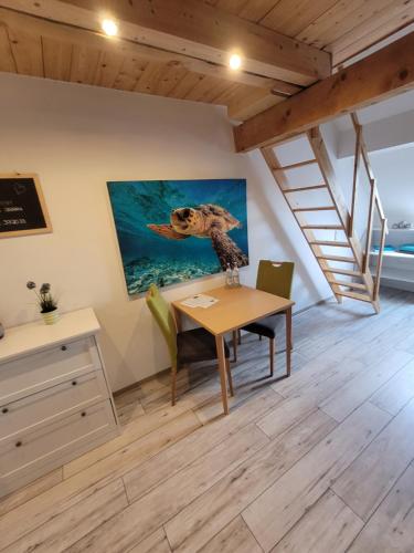 a dining room with a table and a painting of a turtle at Rennsteigscheune in Steinbach am Wald