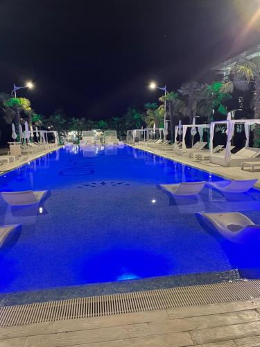 a large swimming pool with blue water at night at Dreamland oasis in Chakvi in Chakvi
