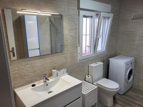a bathroom with a sink and a toilet and a mirror at ZARAPITO in Chiclana de la Frontera