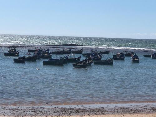 a group of boats in the water at the beach at Dar SAADA maison de sylvie in Souira Guedima
