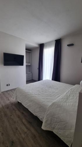 a bedroom with a large bed and a television at Suite Apartments in Cervia