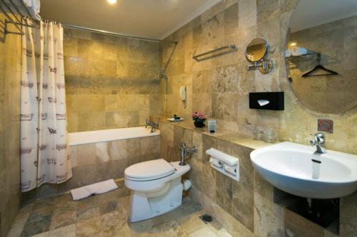 ein Badezimmer mit einem weißen WC und einem Waschbecken in der Unterkunft Jakarta Airport Hotel in Tangerang