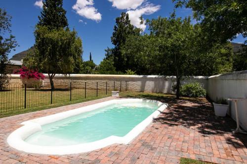 a swimming pool in a yard with a fence and trees at De Kothuize 166 in Graaff-Reinet