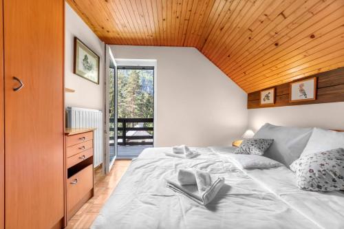 a bedroom with a large bed with a wooden ceiling at Primula Cottage, a step away from Kranjska Gora in Kranjska Gora