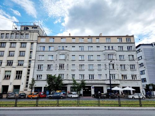 un gran edificio blanco con coches estacionados frente a él en Noclegi Stadion Bed & Breakfast, en Varsovia