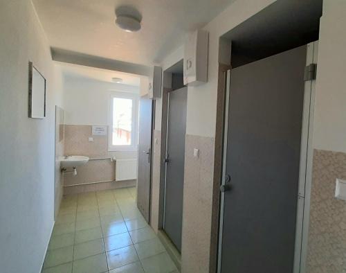 a hallway of a bathroom with a sink and a door at Hostel Centrum-Kamienica 1924 in Szczecinek