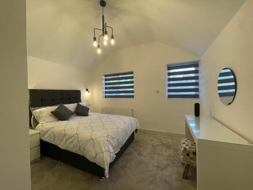 Schlafzimmer mit einem Bett, einem Schreibtisch und Fenstern in der Unterkunft Star London Finchley Road 3-Bed Oasis with Garden in London