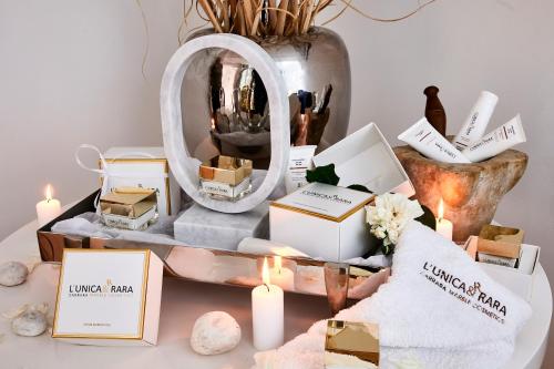 a table with candles and a mirror and a pile of boxes at Mondial Resort & Spa in Marina di Pietrasanta