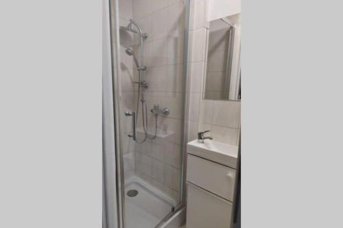 W łazience znajduje się prysznic i umywalka. w obiekcie Pokój dla dwojga w zacisznej części Sopotu z łazienką wspólną dla dwóch pokoi w mieście Sopot