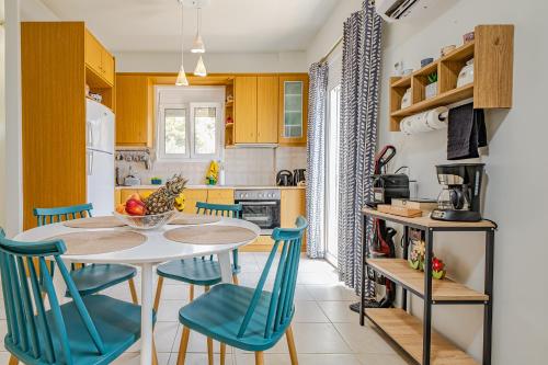 a kitchen with a table and blue chairs at Plakias River Apartment in Plakias