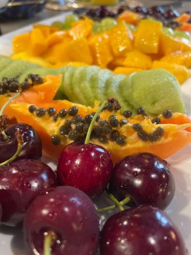 a plate of fruit with apples oranges and other fruits at 34 GuestHouse in Setúbal