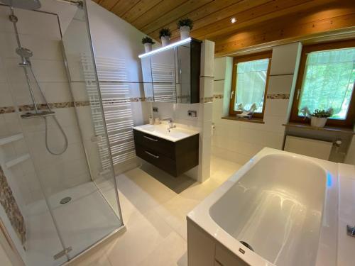 een badkamer met een bad, een wastafel en een douche bij Villa Hochbahn in Schönau am Königssee in Schönau am Königssee