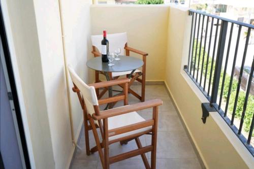 een balkon met een tafel en een fles wijn bij APARTMENTS BY THE SEA in Gázion